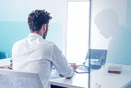 Mitarbeiter sitzt am Schreibtisch im Büro